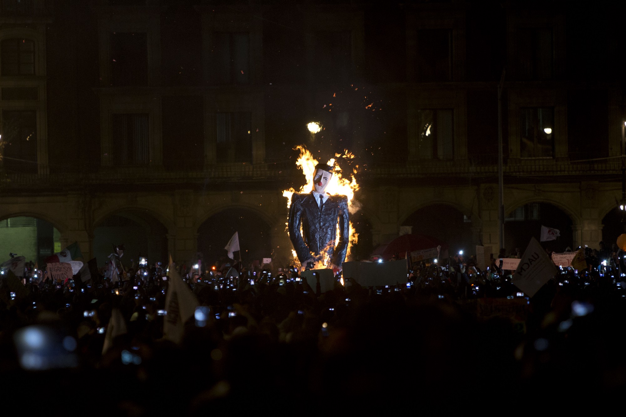 Una efigie que representa a Enrique Peña Nieto fue prendida en fuego durante una protesta masiva. Los manifestantes exigen justicia por los desaparecidos de Ayotzinapa.