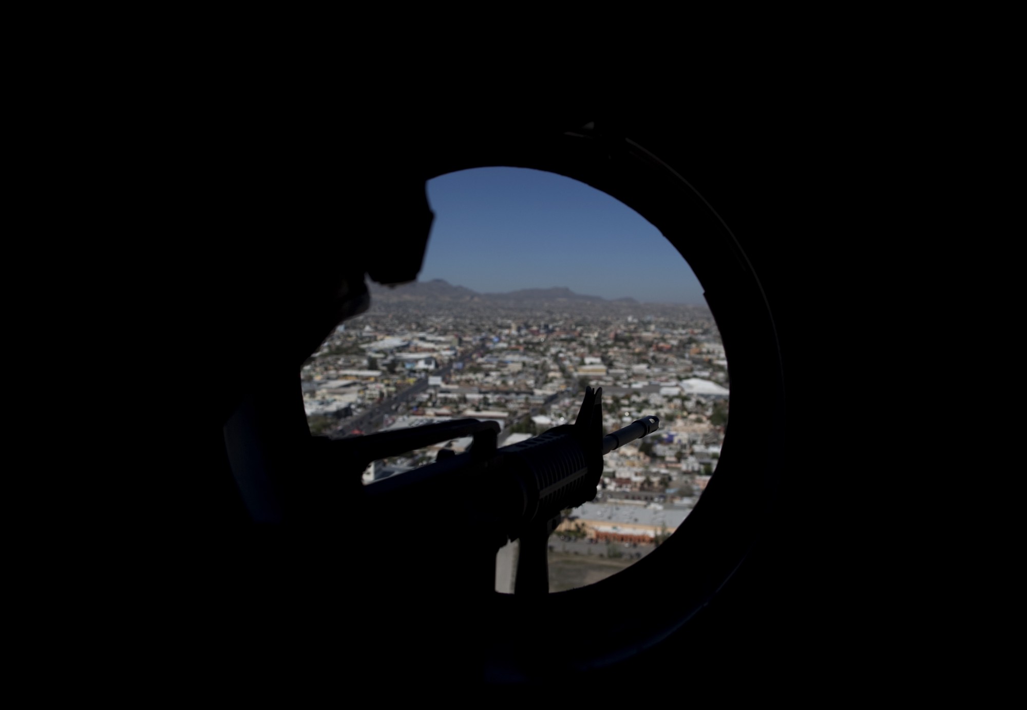 Un francotirador vigila en un helicóptero que vuela sobre Ciudad Juárez, Chihuahua.