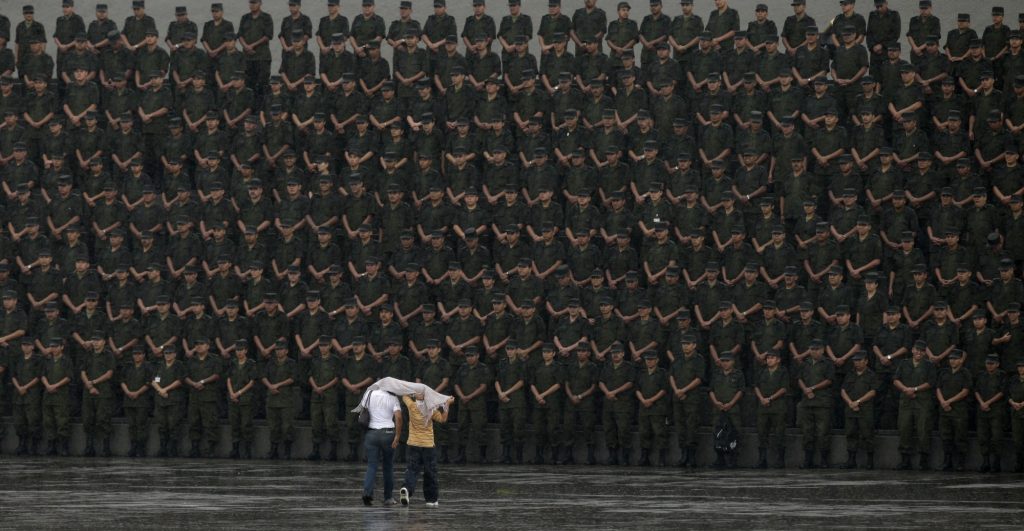 Dos personas caminan hacia un grupo de soldados en una ceremonia militar el día 14 de septiembre de 2009.
