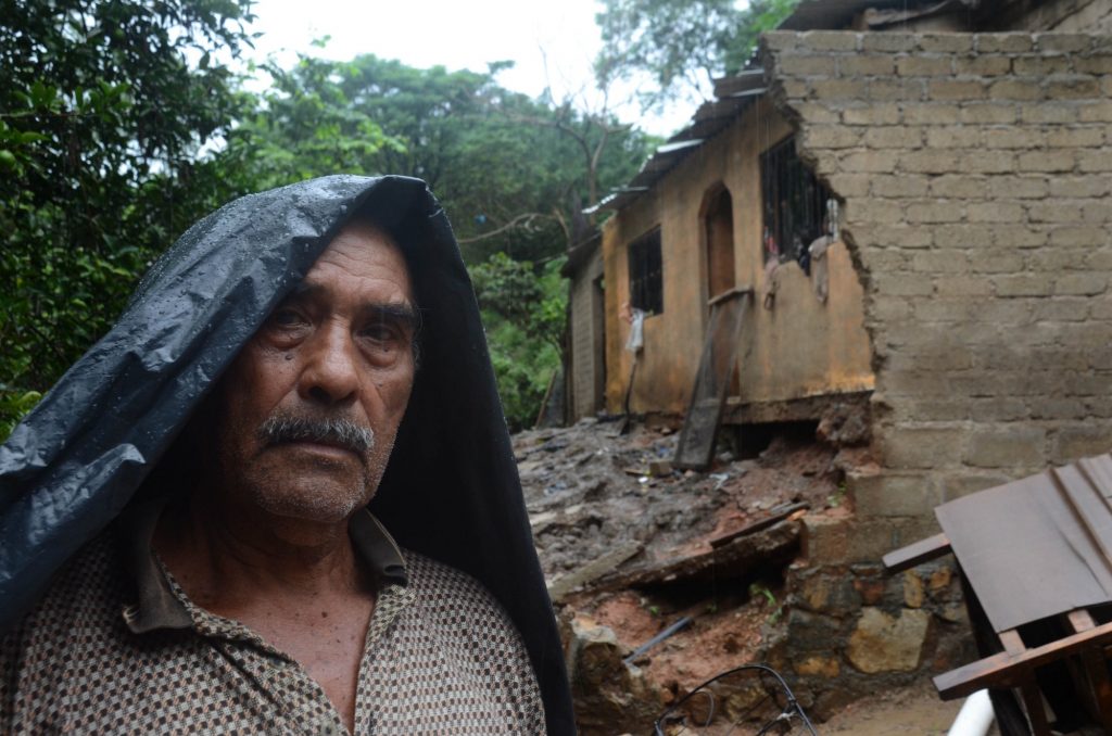 Un hombre de la comunidad Papa Gallo de Tierra Colorada en las cercanías de Acapulco, se para junto a su casa que fue afectada por el Huracán Manuel y en el momento de la foto por el Huracán Raymond.