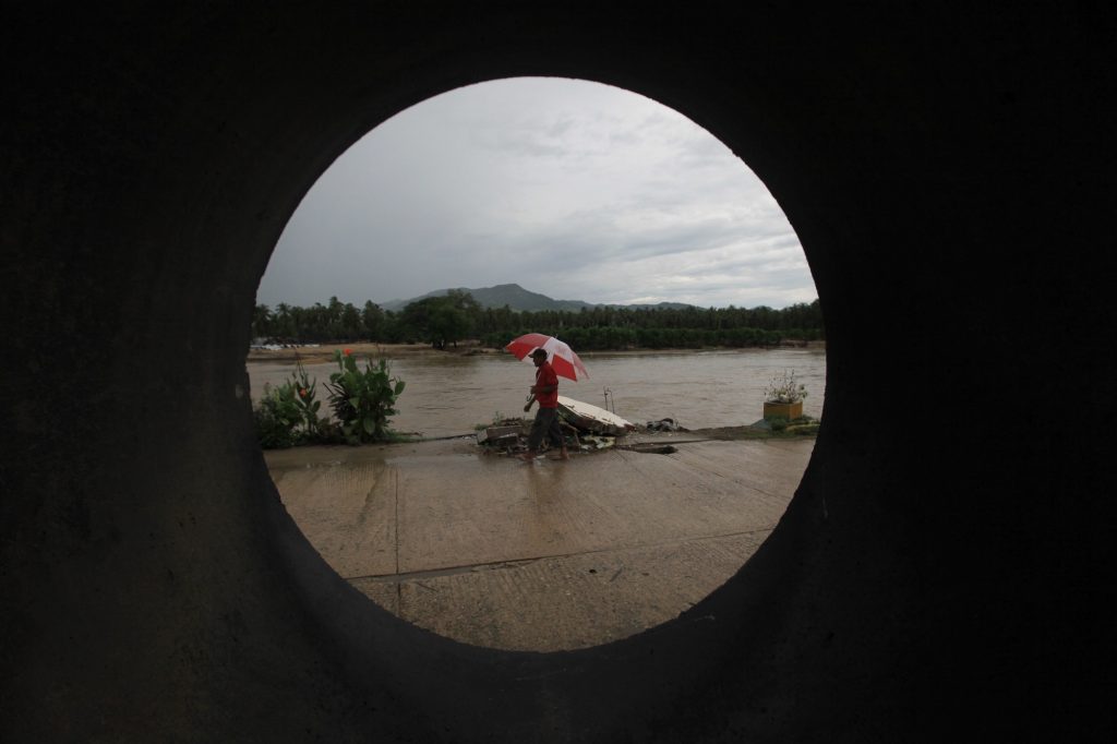 Un hombre camina en Coyuca, Guerrero cuando el huracán Manuel se tranquilizaba.