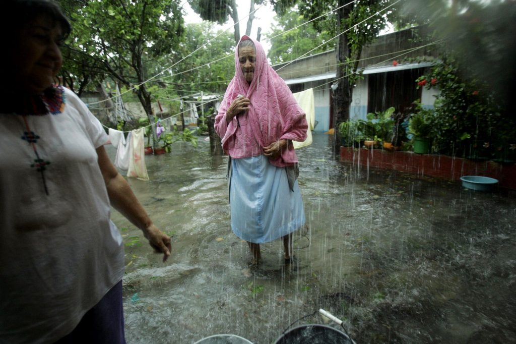 En el pueblo de Sabancuy, María Hernández, 72 años, camina con una toalla en la cabeza afuera de su casa inundada tras la llegada del huracán Dean.