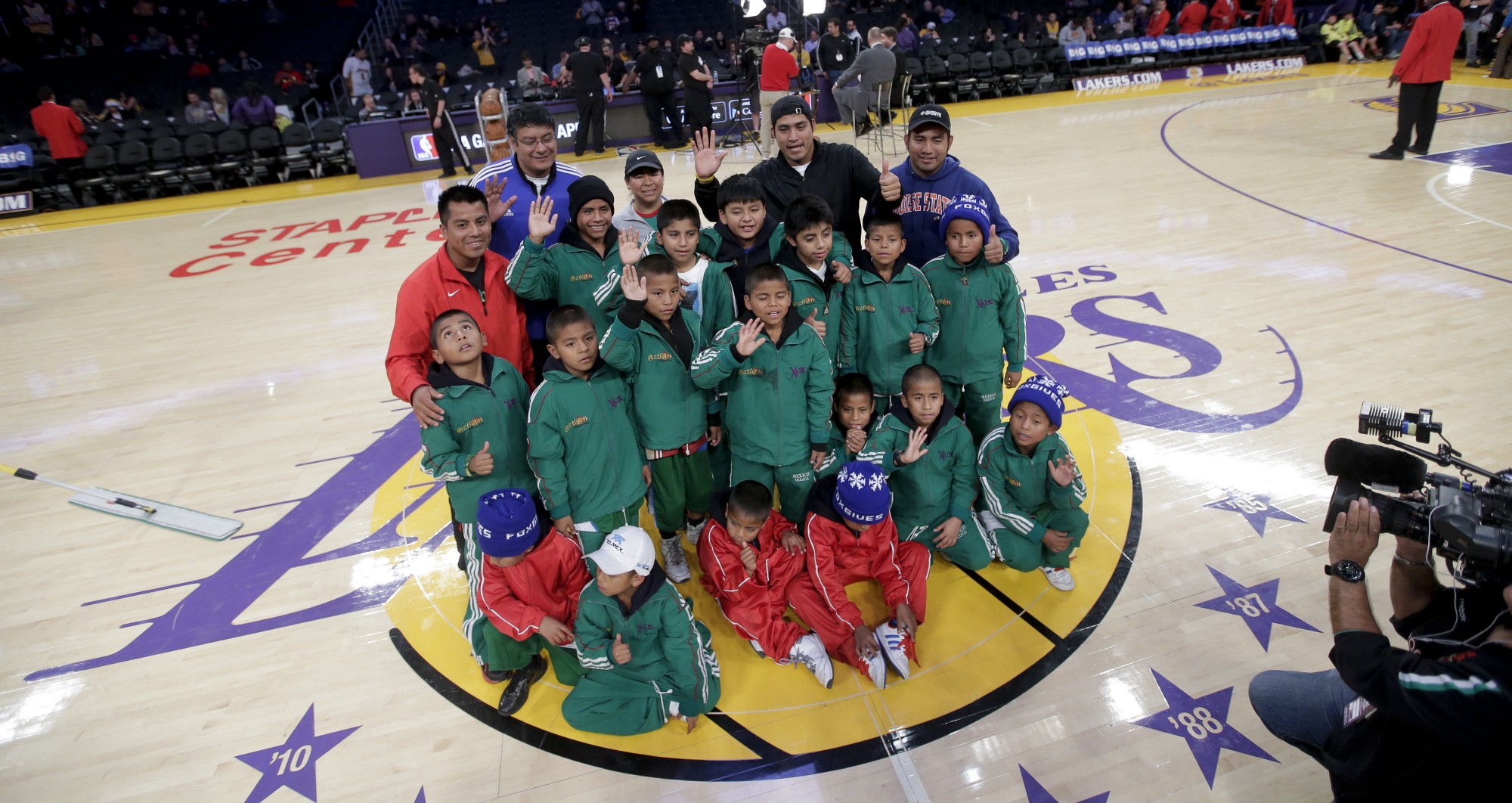 Miembros del equipo de básquetbol del equipo Triqui posan para una foto en la cancha de los Lakers de Los Ángeles.