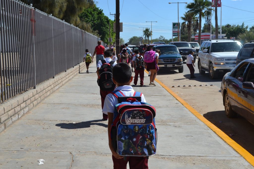 Niños con sus padres caminan a la escuela. 