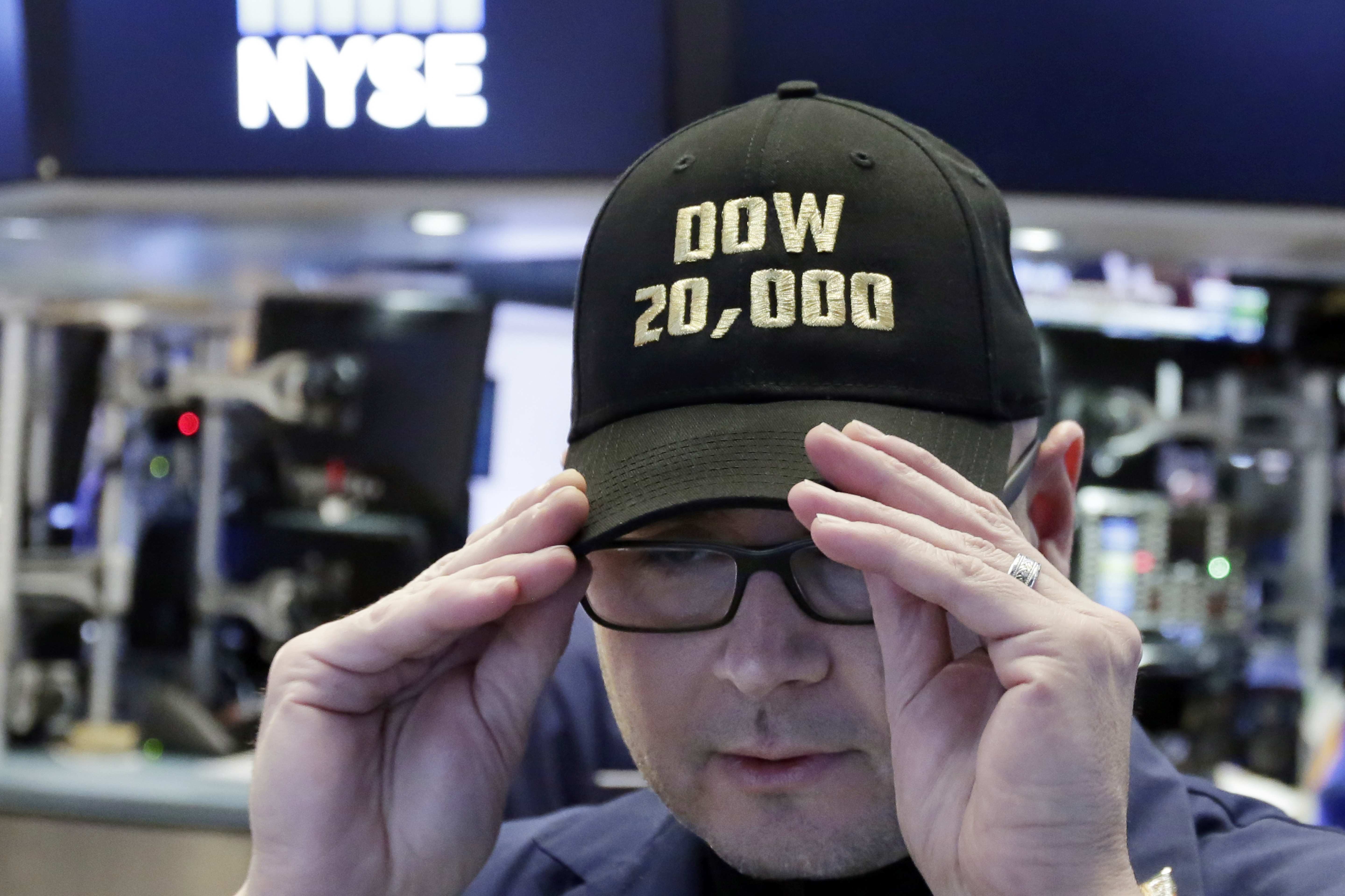 Operador celebra con una gorra la marca histórica de 20 mil puntos del Dow Jones en Wall Street (AP)
