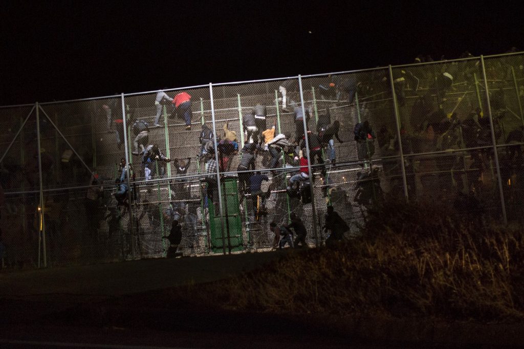 Personas procedentes de países subsaharianos intentan cruzar la gran valla que separa el enclave español de Melilla de Marruecos