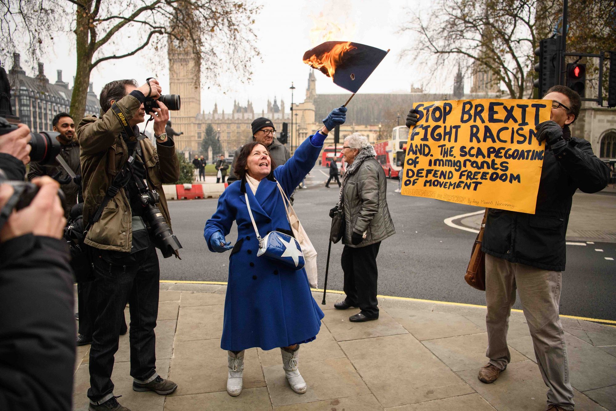Mujer quema bandera de la Unión Europea (centro), hombre en contra de Brexit sostiene pancarta (derecha).