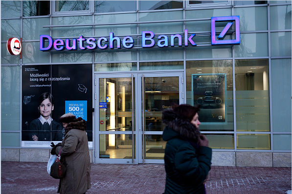 Varias personas caminan cerca de una sucursal del Deutsche Bank en Polonia.