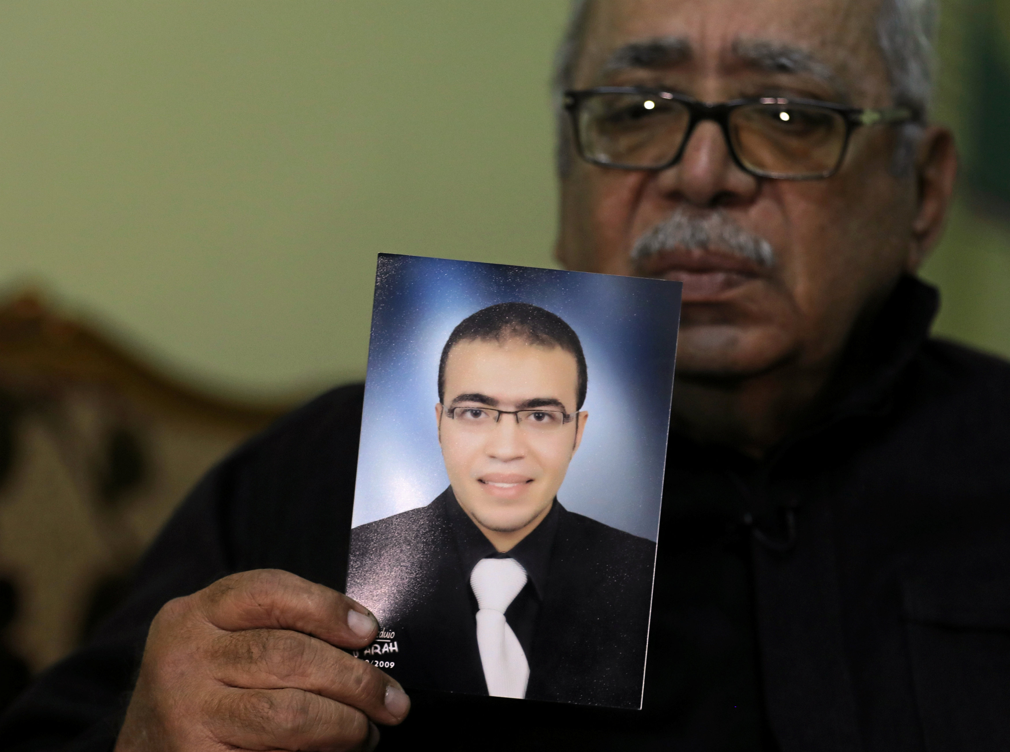 Reda Abdullah al-Hamamy, padre de Abdullah Reda al-Hamamy, sospechoso de atacar a un soldado en el Museo del Louvre de París sostiene una foto de su hijo durante una entrevista con Reuters en Daqahliya, Egipto. (Archivo)