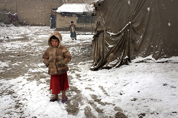 Un niño se encuentra parado afuera de la choza de barro donde vive su familia en Kabul. (Getty Images)