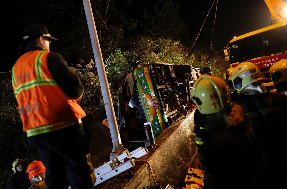 Un grupo de rescatistas se reúnen alrededor de un autobús volcado en Taipei, Taiwán donde viajaban 45 personas (Reuters)