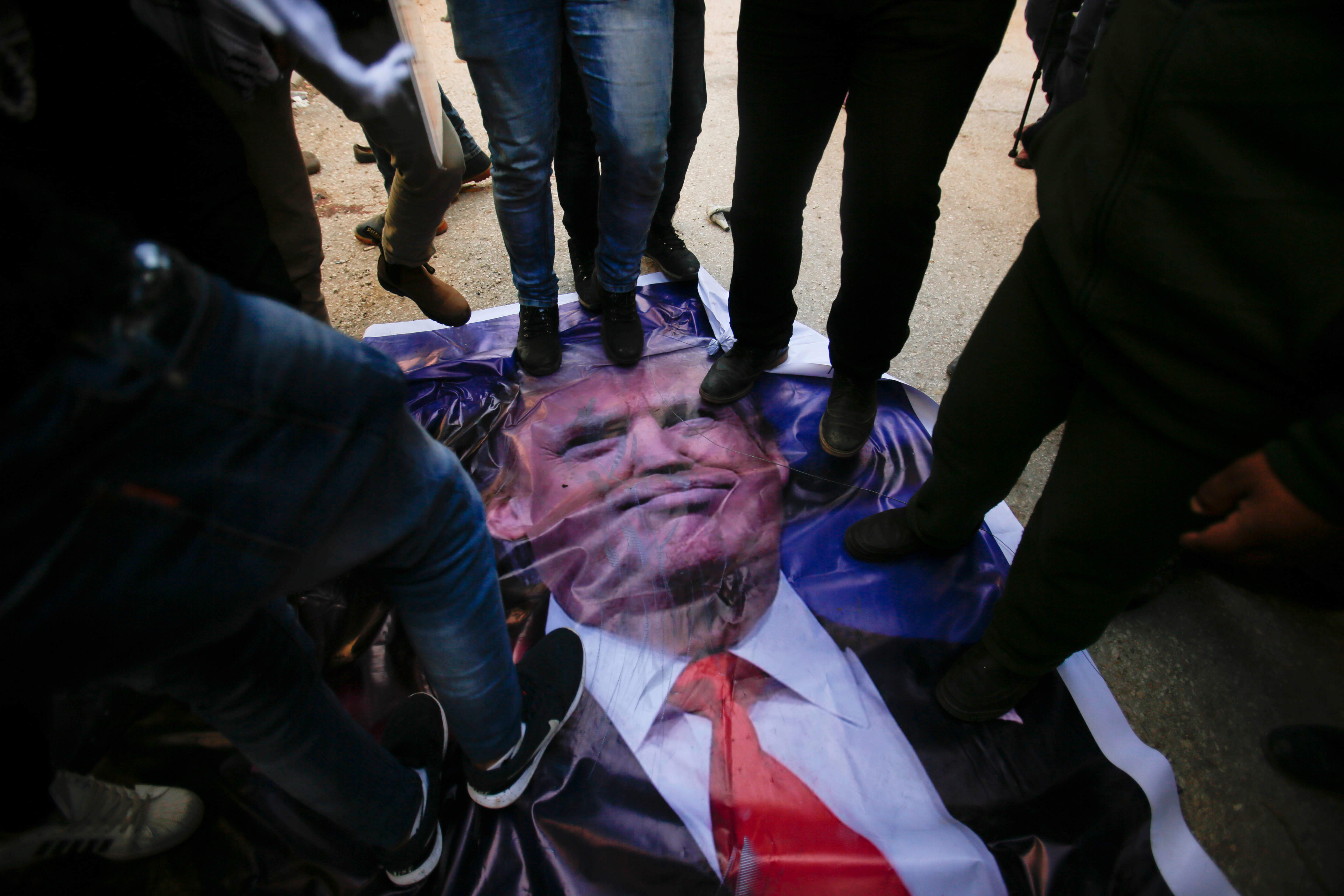 Durante las protestas en la ciudad de Hebrón, algunos palestinos pisotearon un cartel del presidente estadounidense Donald Trump . (AP)