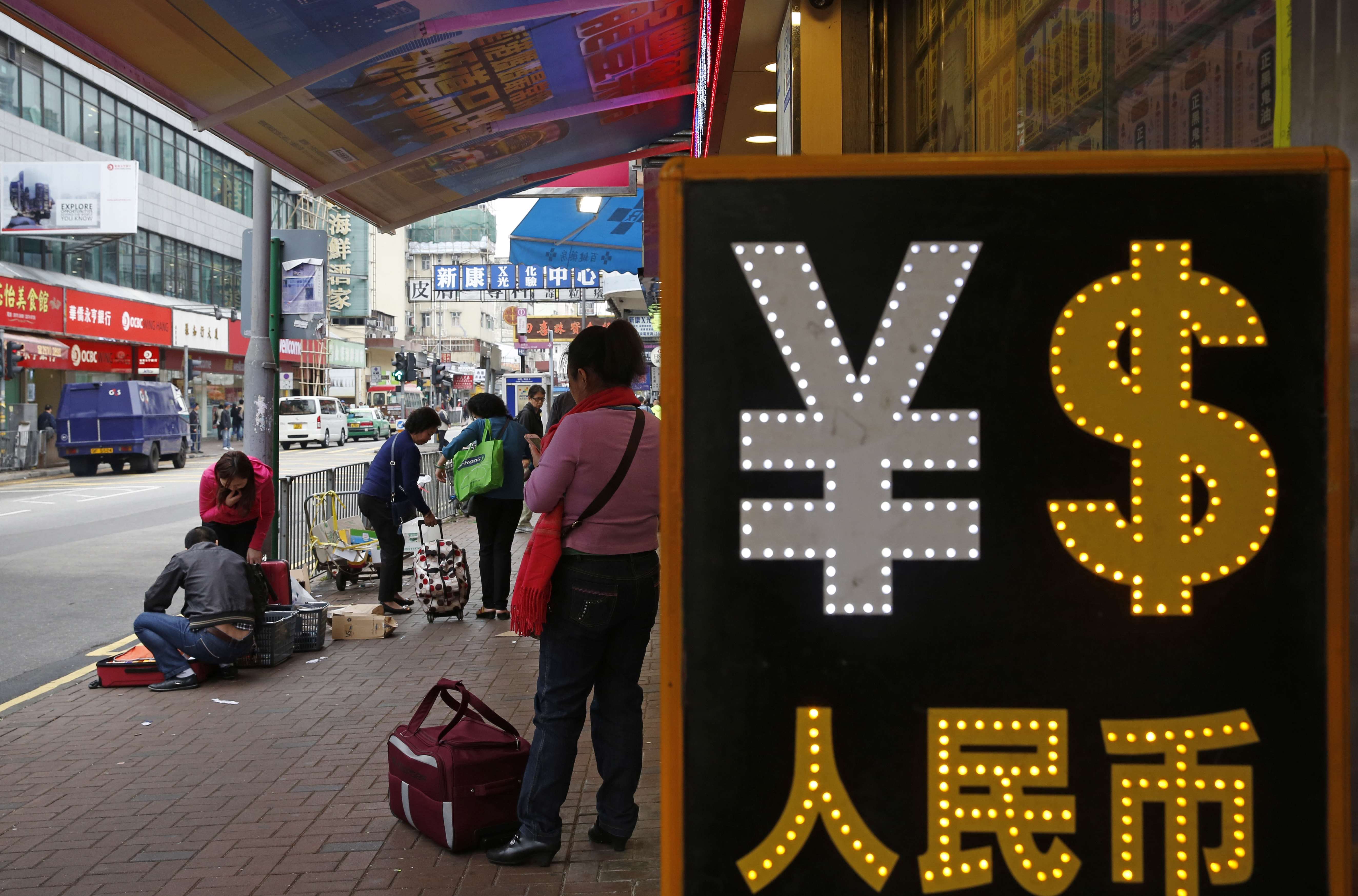 Vista de una casa de cambio con los símbolos de la moneda china y el dólar (AP)