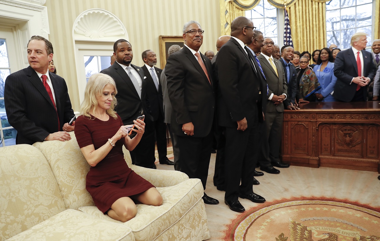 Kellyanne Conway, asesora de Donald Trump, se sienta en un sofá mientras el presidente de Estados Unidos da la bienvenida a los líderes de universidades afroamericanas en el Despacho Oval (AP)