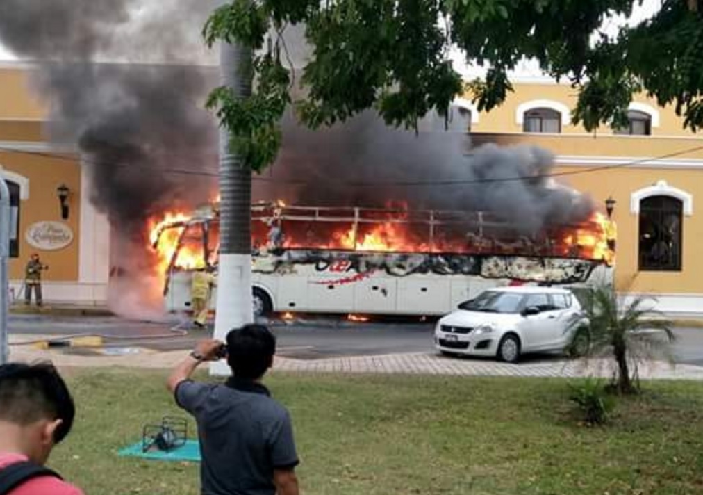 Un autobús turístico se incendió en el centro histórico de Campeche; bomberos controlaron el fuego que dañó también a dos vehículos estacionados cerca del lugar y parte de la fachada de un hotel.