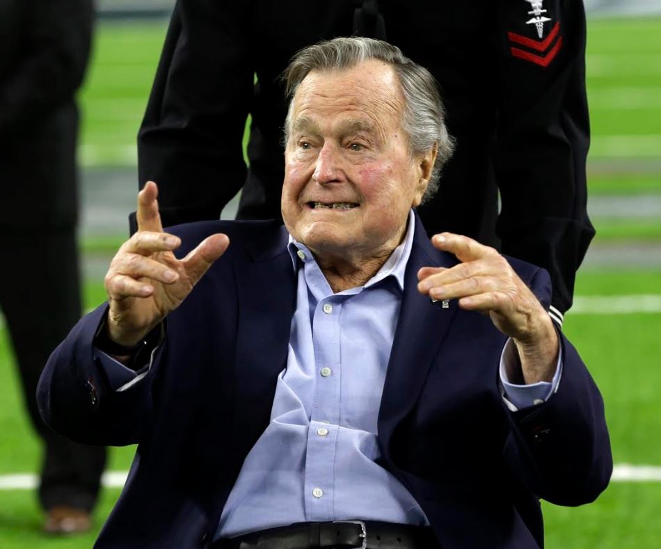 El expresidente George Bush, padre, acompañado de su esposa Barbara Bush, fue el encargado de lanzar la moneda al aire (AP)
