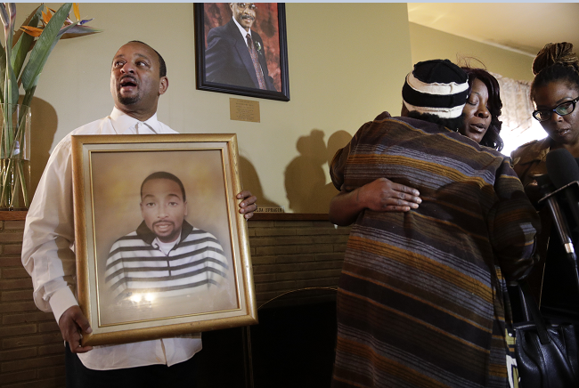 Familiares sostienen un retrato de Ezell Ford, un joven muerto a tiros por la policía de Los Ángeles.