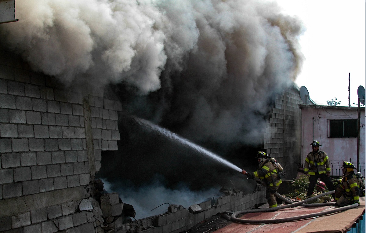 Bomberos de Tijuana sofocan un incendio que afectó a un taller de carrocería, un almacén de alfombras y parte de unos departamentos