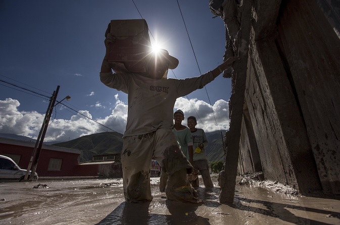 Residentes de la provincia de Jujuy, en Argentina, llevan su pertenencia a los techos de sus casas inundadas (AP)