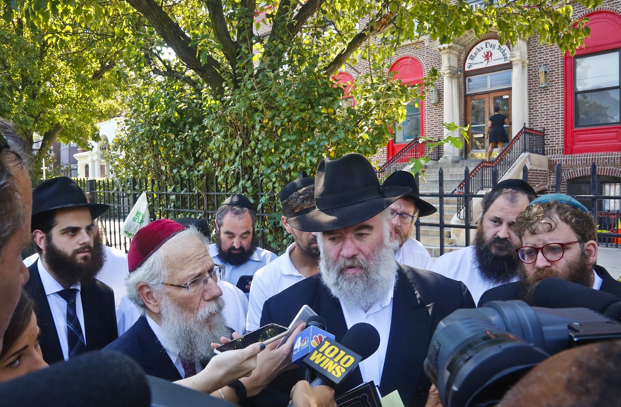 El rabino Shea Hecht, a la izquierda, y Norman Rosenbaum, centro, celebran una rueda de prensa sobre violencia racial (AP/archivo)