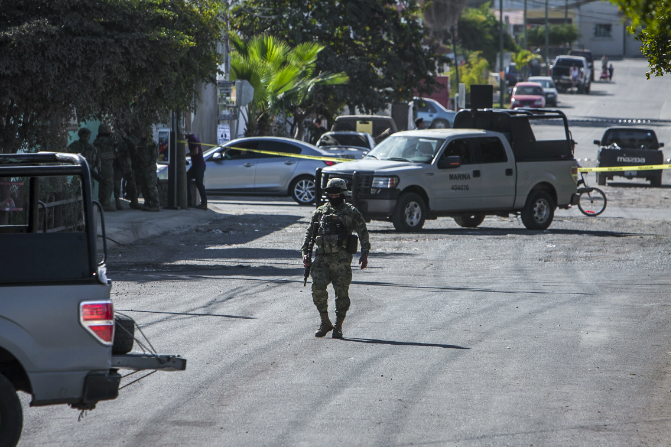Un marino camina en una calle cercana donde se registró un enfrentamiento en Culiacán, Sinaloa (AP)
