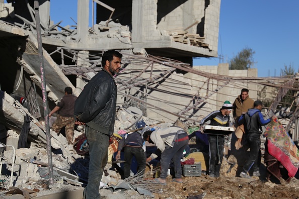La gente inspecciona los escombros de edificios dañados tras un bombardeo por fuerzas del régimen de Bashar al-Asad (Getty Images)