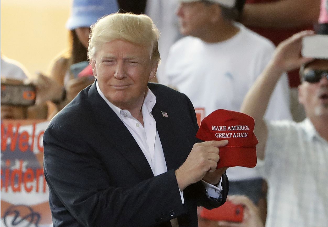 El presidente Donald Trump apunta a su lema en una gorra, durante el "Make America Great Again Rally" en el Aeropuerto Internacional de Orlando-Melbourne, este sábado. (AP)