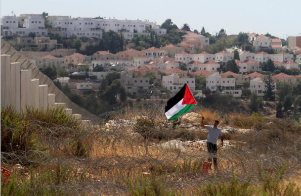Un activista palestino protesta cerca de asentamientos israelíes.