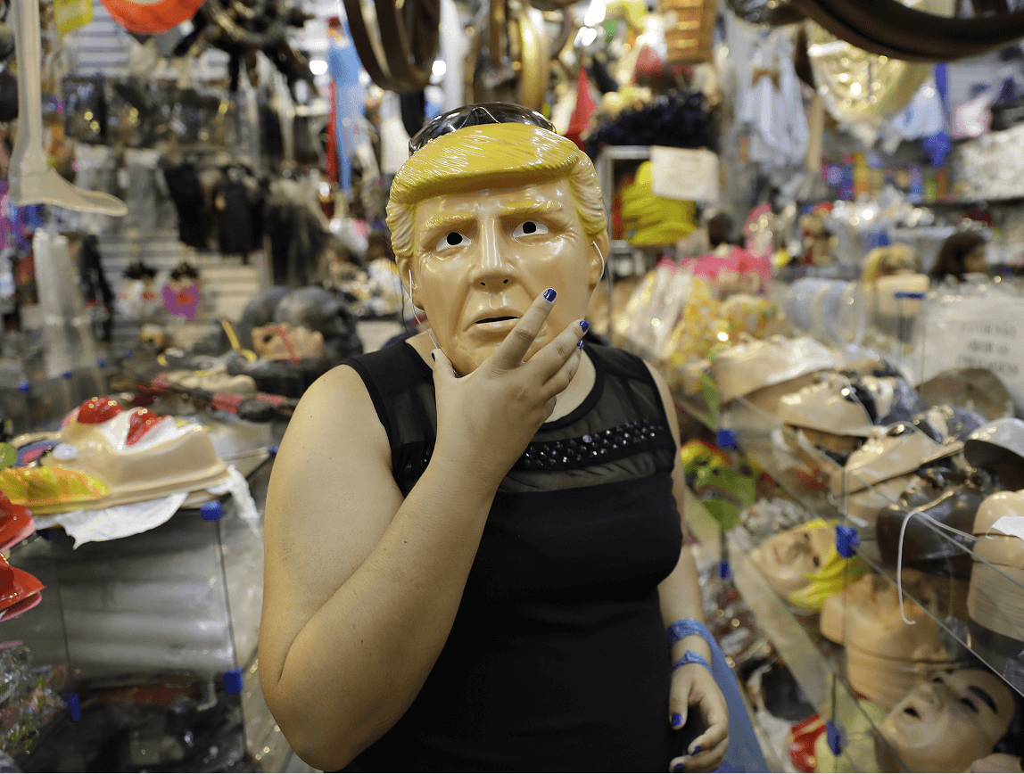 Una mujer se prueba una máscara de Donald Trump en una tienda de Sao Paulo, Brasil. (AP)