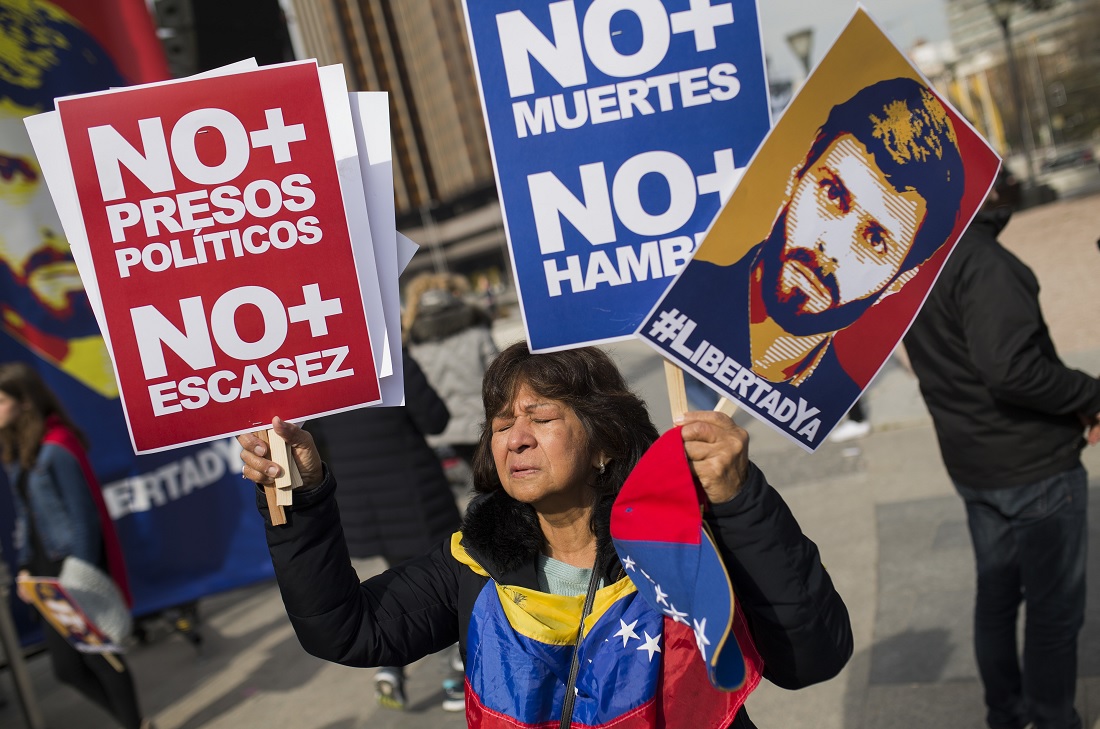 Mujer sostiene carteles con imagen de Leopoldo Lopez