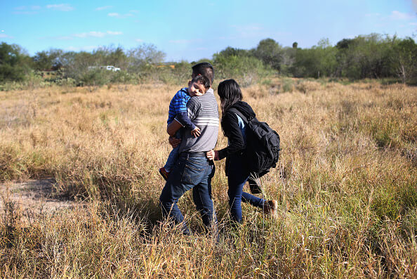 Un padre carga a su hijo durmiente para cruzar ilegalmente la frontera de los Estados Unidos con México cerca de la ciudad de Rio Grande, Texas. (Getty Images)