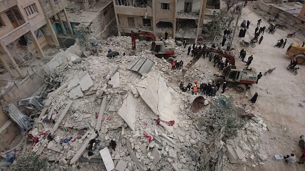 Un grupo de rescatistas con máquinas de excavación inician la búsqueda de cuerpos bajo los escombros después de que los Warcrafts llevaron a cabo ataques aéreos en el distrito de Kusur de Idlib, Siria. (Getty Images)