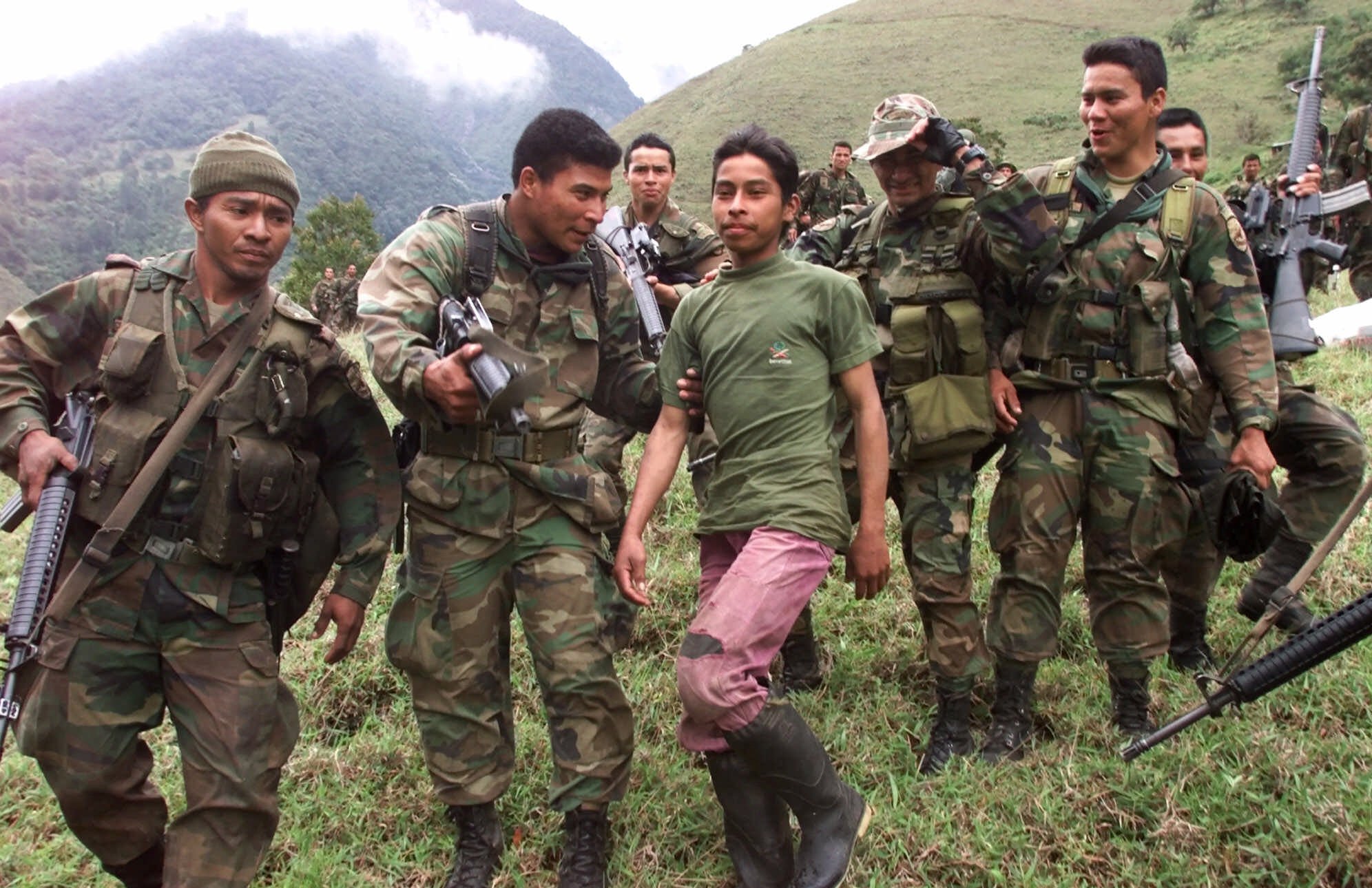 Soldados escoltan a un adolescente rebelde, de 13 años de edad, de las Fuerzas Armadas Revolucionarias de Colombia (FARC) que fue capturado en las montañas del estado de Santander, en el noroeste de Colombia. (AP/archivo)