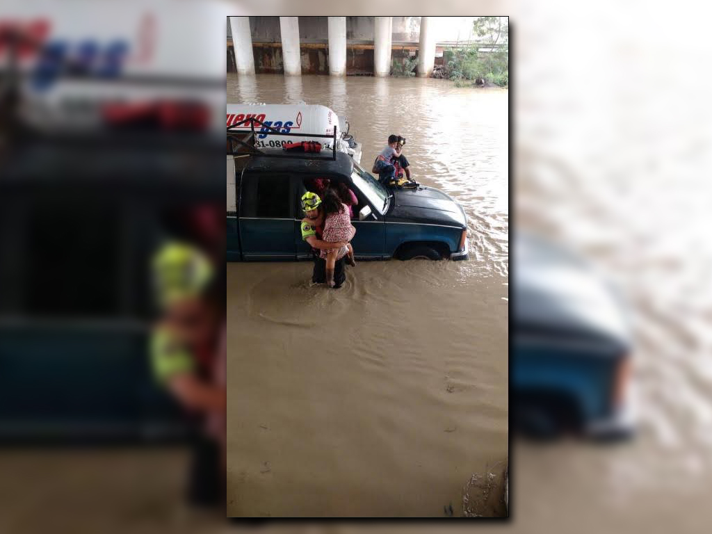 Rescatista auxilia a varias personas que quedaron varadas en el arroyo San Martín, municipio de García (Twitter @_LASNOTICIASMTY)