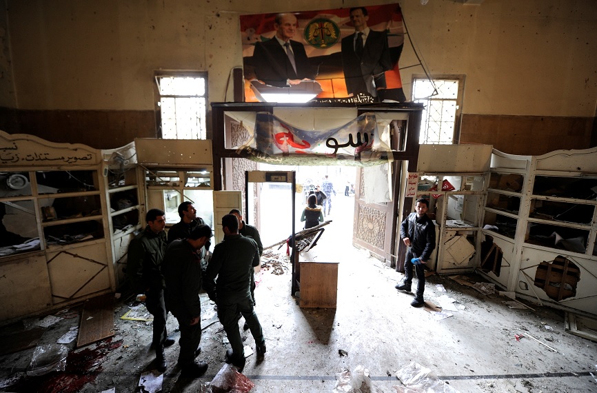 Personal de seguridad permanece cerca de una entrada dañada después de una explosión suicida en el palacio de justicia en Damasco, Siria, (Reuters)