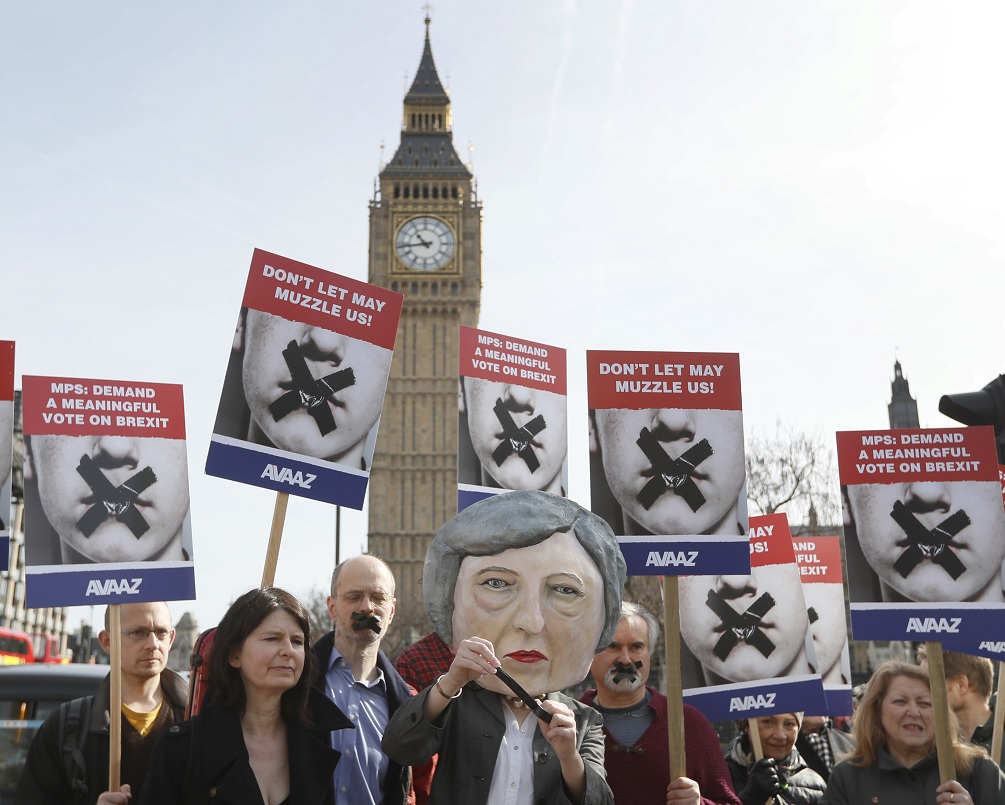 Un grupo de manifestantes utilizan una cabeza de títere de Theresa May y posan cerca del parlamento en Londres (AP)