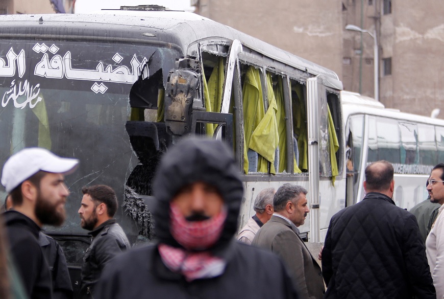 La gente inspecciona el daño en el sitio de un ataque de dos atacantes suicidas en Damasco, Siria (Reuters)