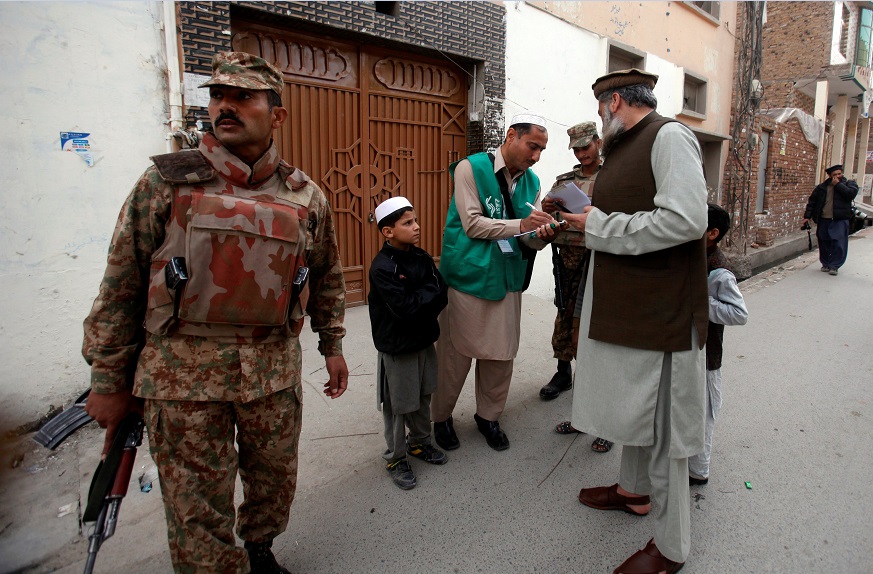 Militar a compaña a encuestador que realiza censo de población en Pakistán (Reuters)