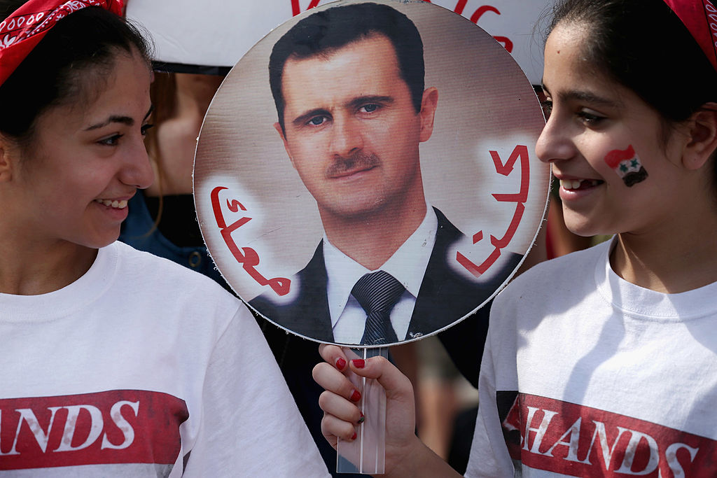 Dos niñas sostienen un cartel con la imagen del presidente sirio Bashar al Assad.
