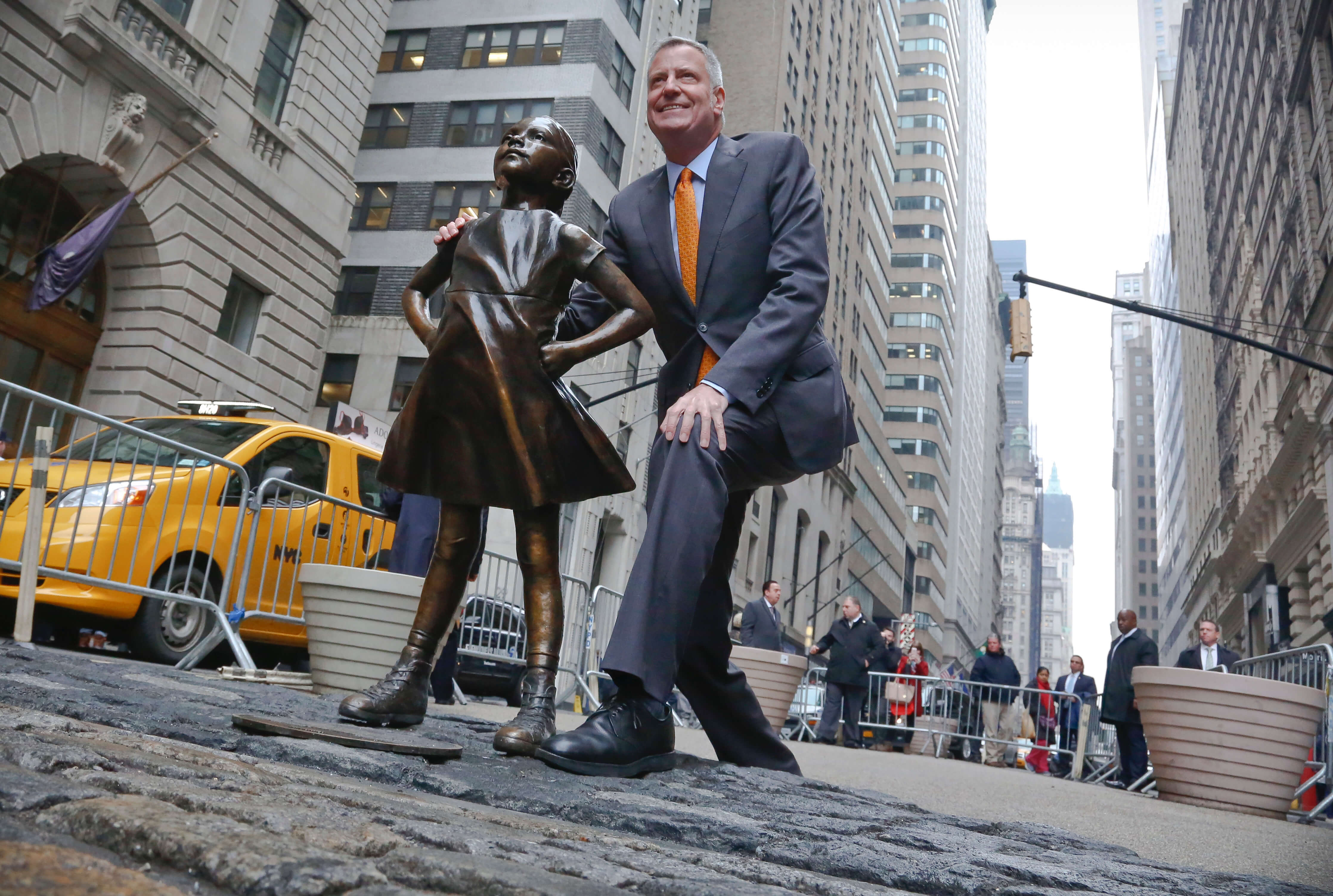 El alcalde de Nueva York, Bill de Blasio, posa junto a la escultura de la 'Niña sin Miedo' en Wall Street (AP)
