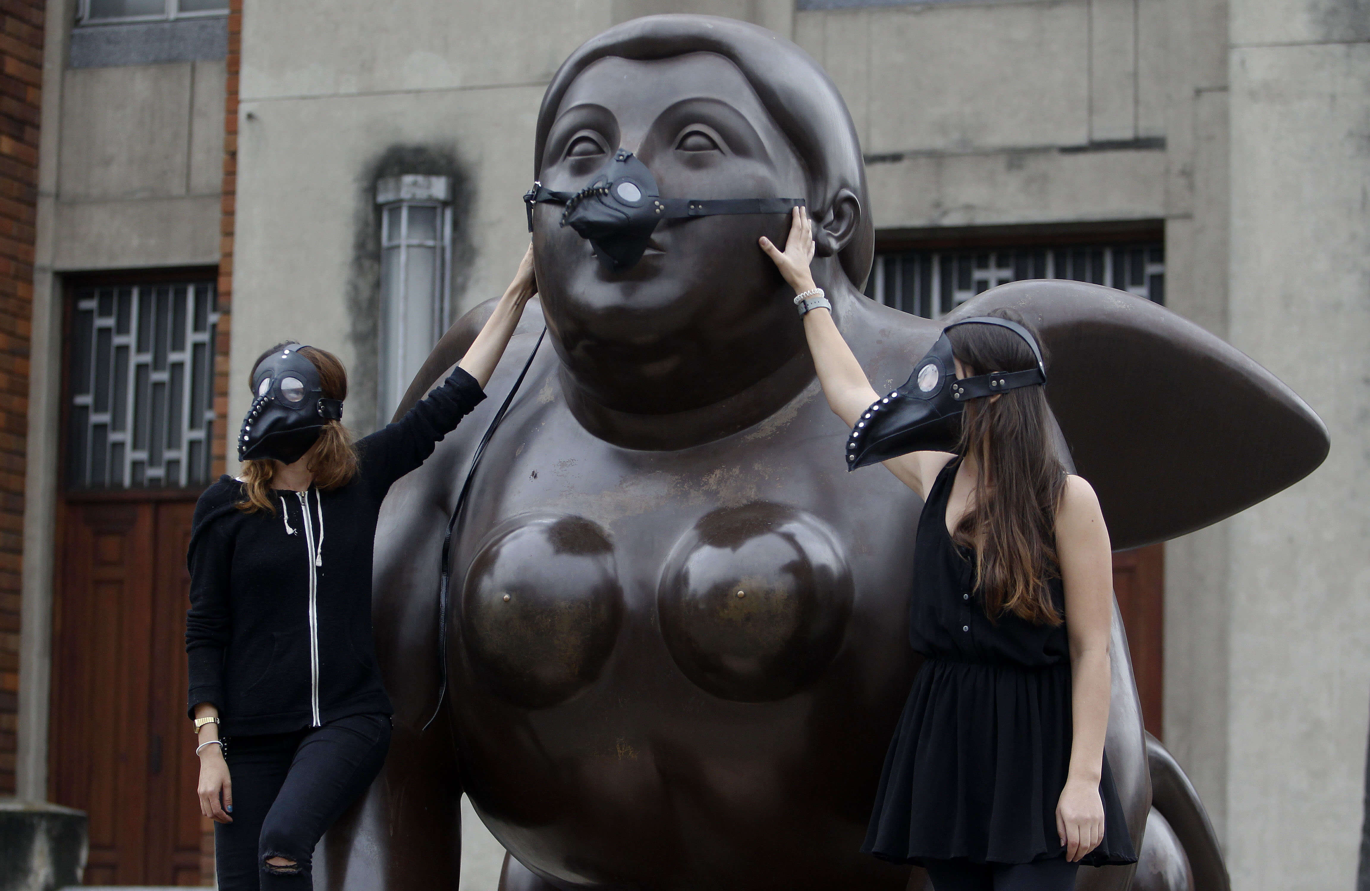 Vista de la obra "Esfinge" del artista Fernando Botero, trae puesta una máscara de médicos de la peste negra, colocada por ambientalistas en la Plaza Botero en Medellín, Colombia. (EFE)