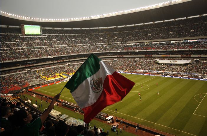 Un aficionado agita la bandera de México durante un partido de fútbol con Costa Rica en el Estadio Azteca. (AP)