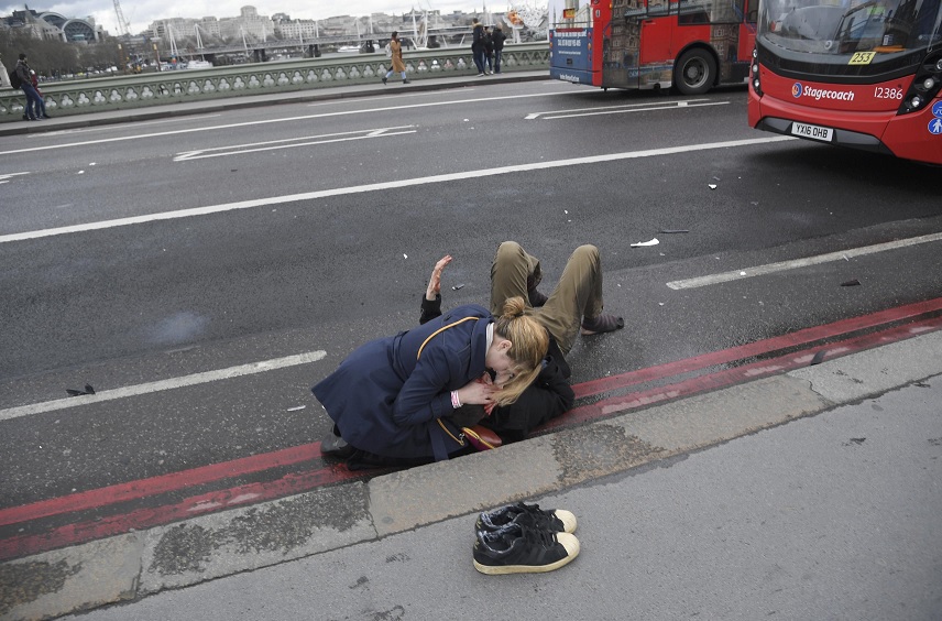 Una mujer ayuda a una persona herida después de un incidente en el puente de Westminster en Londres (Reuters)