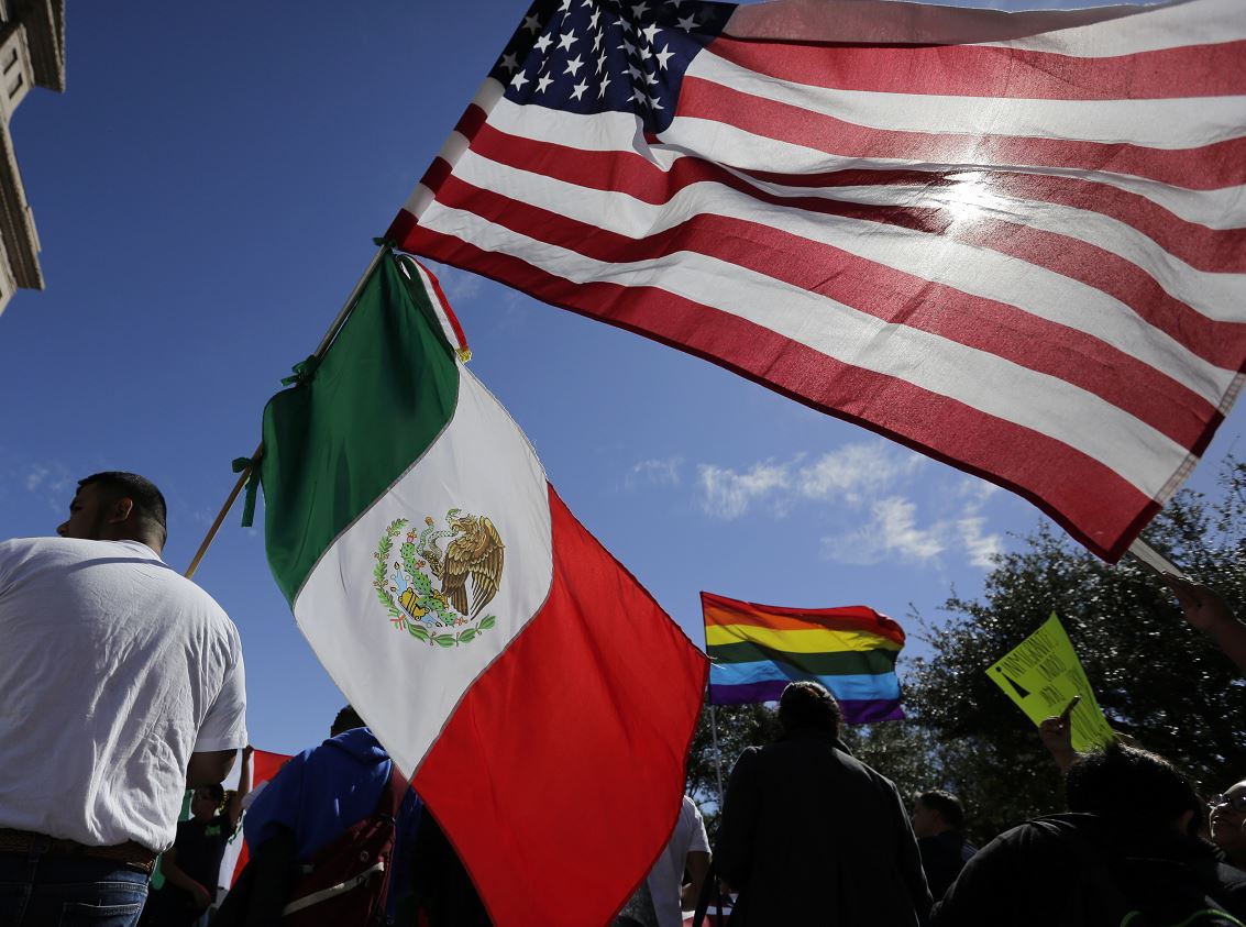 Hombre sostiene banderas de México y Estados Unidos (AP, archivo)