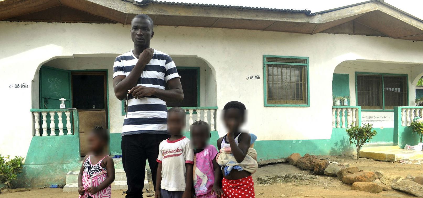 James Harris viudo de Salome Karwah y sus hijos frente a su casa de Monrovia Liberia. (AP)
