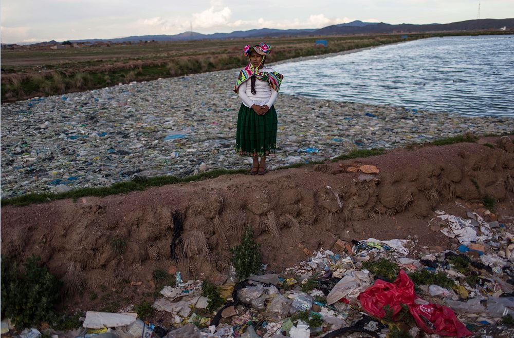La activista medioambiental Maruja Inquilla posa para una fotografía junto a una planta municipal de tratamiento de residuos con agua que fluye al lago Titicaca. (AP)