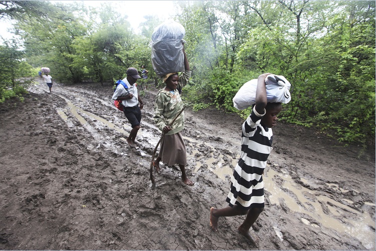 Pobladores de Tsholostho transportan alimento; la región sur de Zimbabue es golpeada por fuertes lluvias e inundaciones (AP)