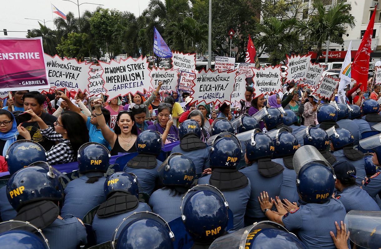 La policía bloquea a manifestantes durante un mitin en la Embajada de los Estados Unidos para celebrar el Día Internacional de la Mujer (AP)