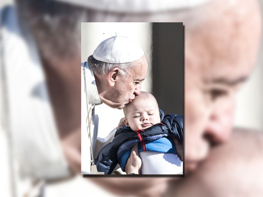El papa Francisco besa a un bebé luego de la audiencia general de los miércoles. (AP)