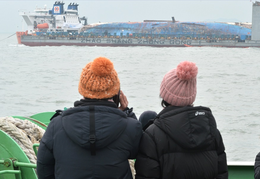Familiares de las víctimas del naufragio de un ferry en Corea del Sur observan los trabajos de reflotamiento (Reuters, archivo)